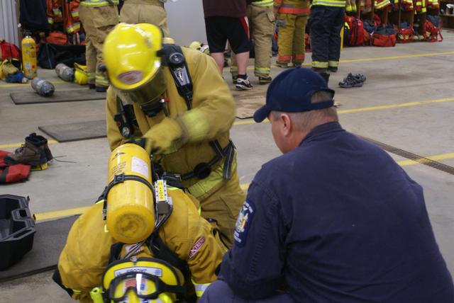 Ross Dubarry conducts an emergency air bottle exchange on fellow SLVFD member Damon Jacobs under the watchful eye of a New York State Fire Instructor 10/16/2010 at the Paul Smiths fire station.